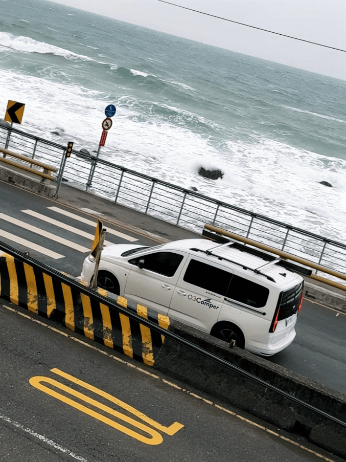 Caddy California 白色車款行駛於濱海公路